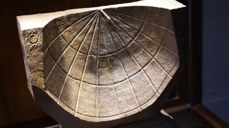 Semicircular ancient sundial with engraved hour lines, displayed at a museum in Türkiye